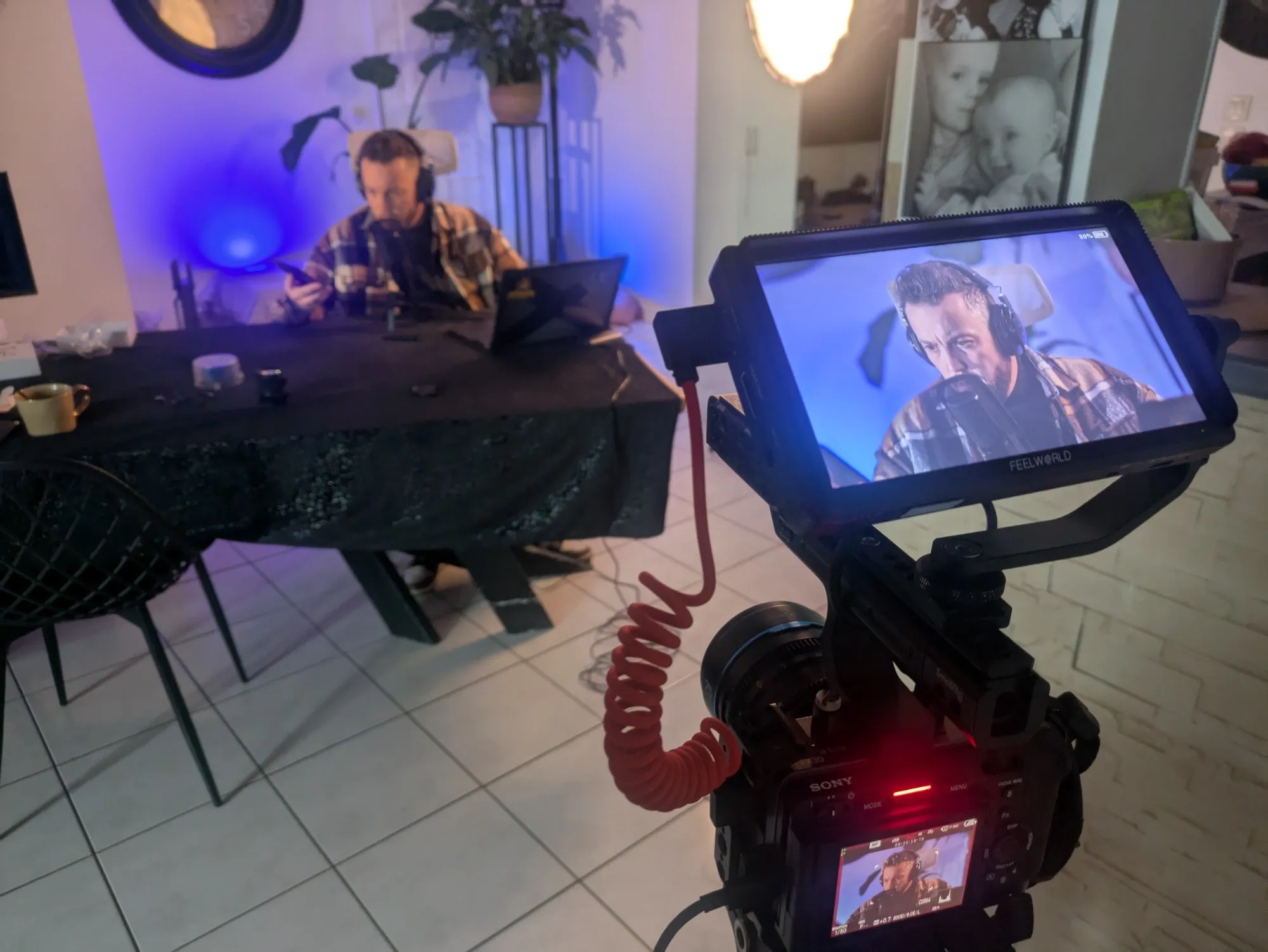 Enregistrement filmé d’un podcast, l’intervenant au micro vu sur le moniteur de la caméra.